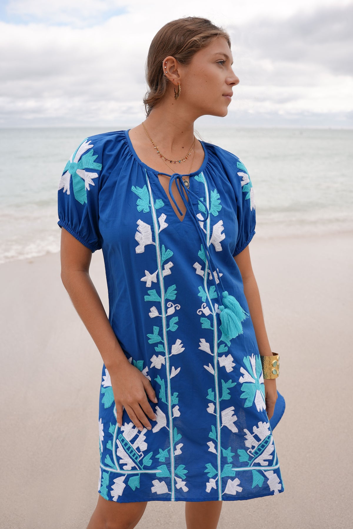 Jessie Embroidered Dress in Blue. Close-up of white and turquoise embroidery and neckline ties.