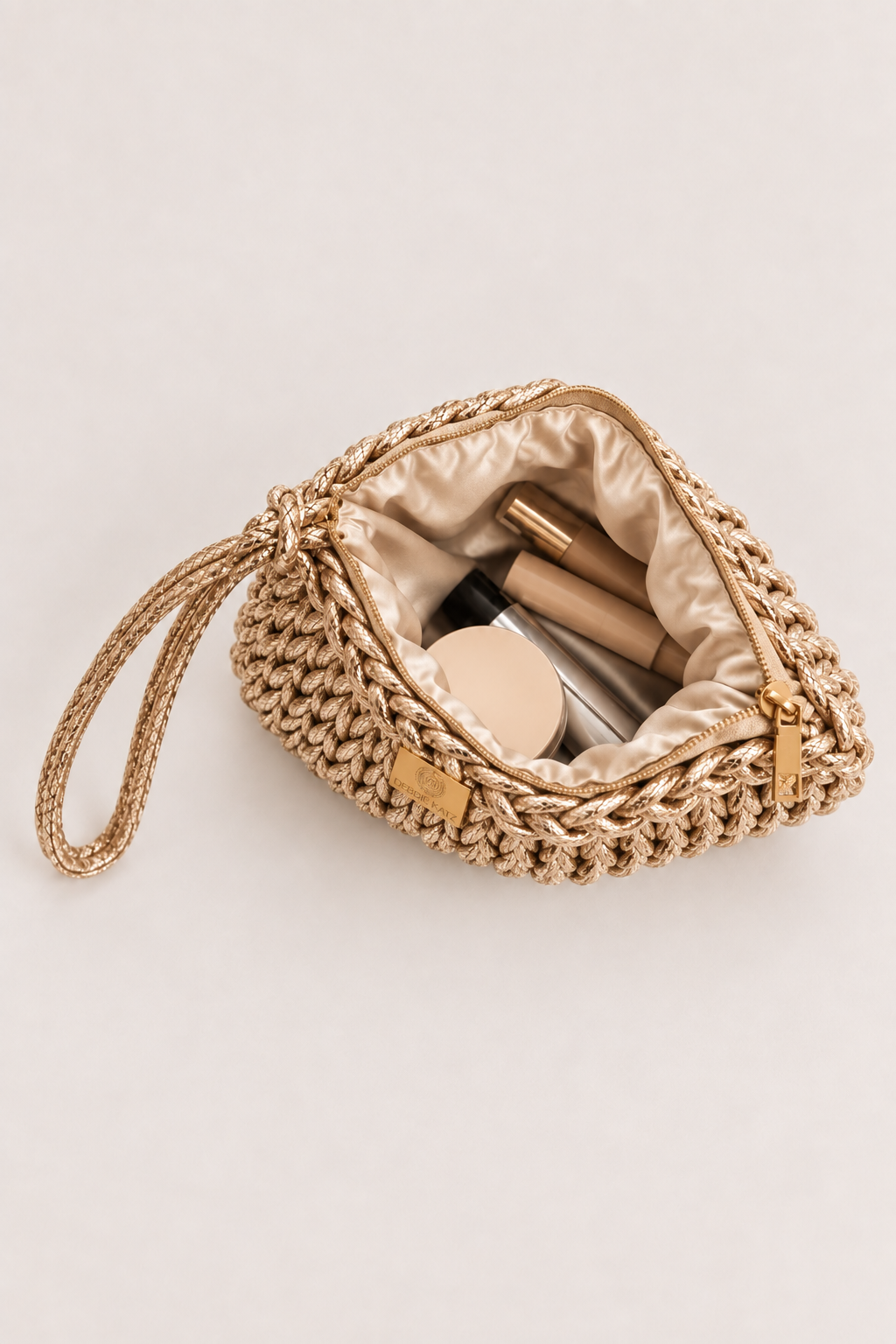 Bardot Crochet Clutch in Light Gold. Lined interior with everyday items.