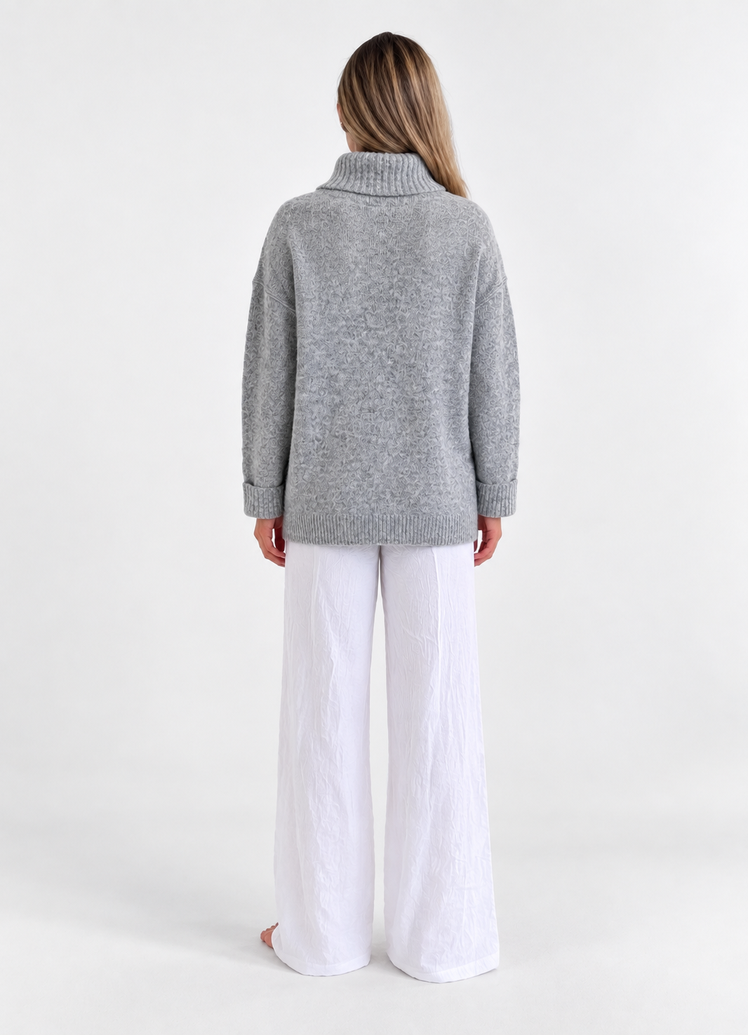 Cozy Turtleneck Sweater in Heather Grey, back studio view with white trousers.
