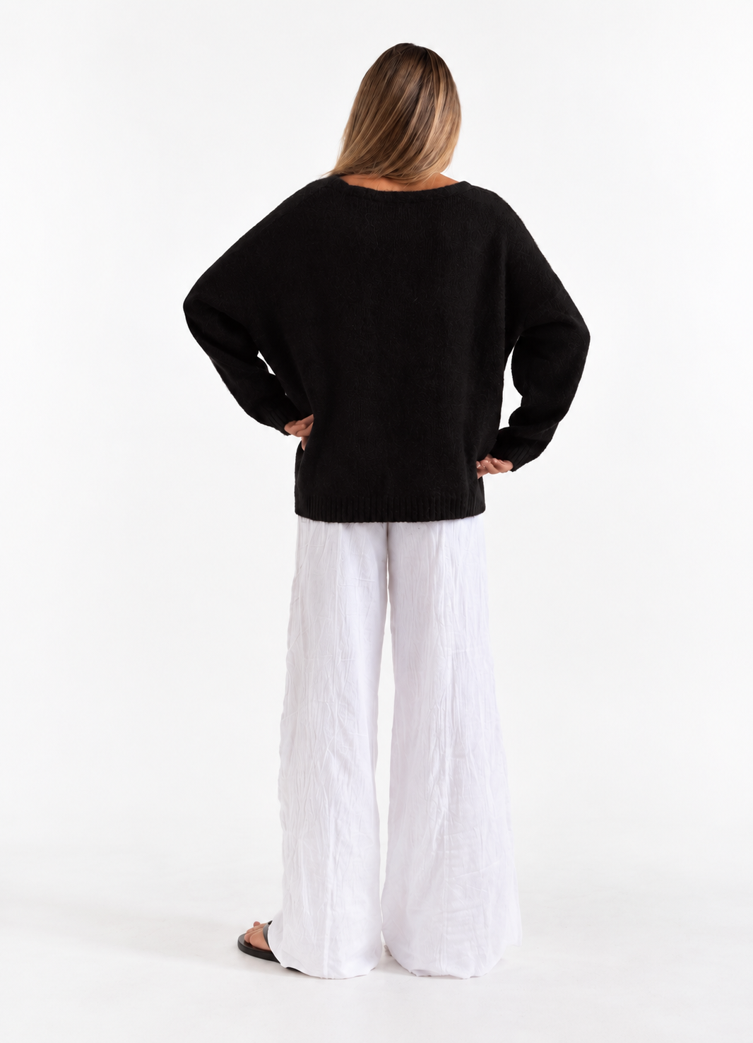 Frost Cardigan in Black, back studio view with white trousers.
