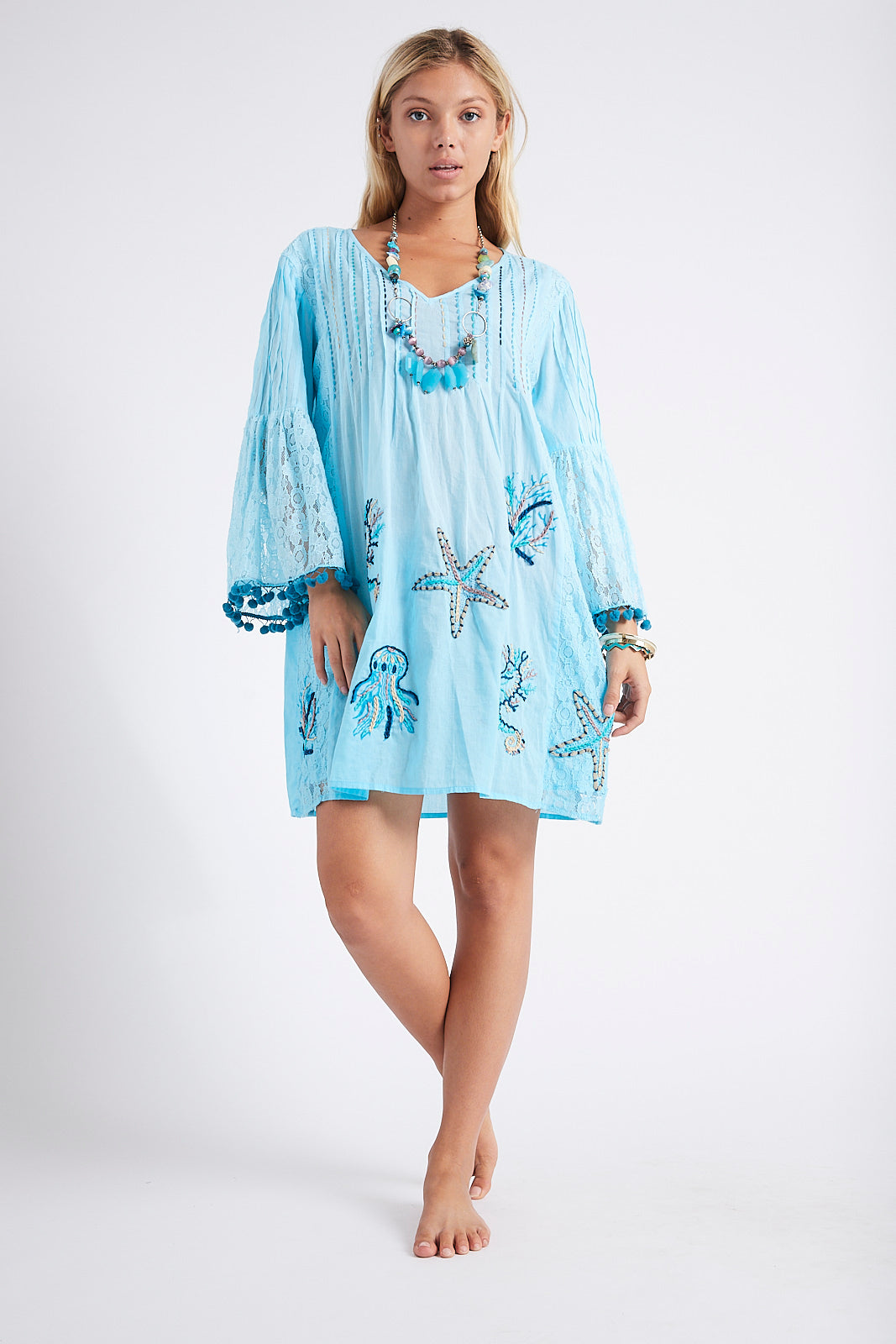 Mara Embroidered Tunic in Blue. Front view showing lace sleeves and hem.