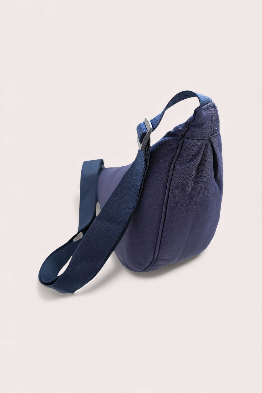 Navy blue sling bag on a beige background
