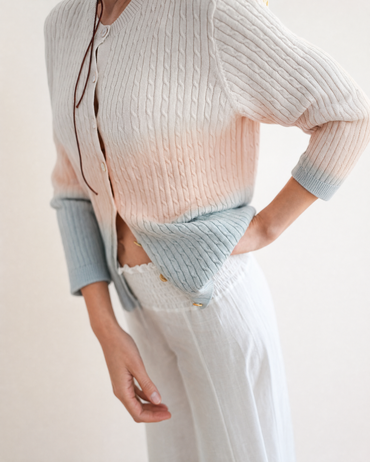 Detail of the Bliss Haze cardigan's cream, peach and grey knit